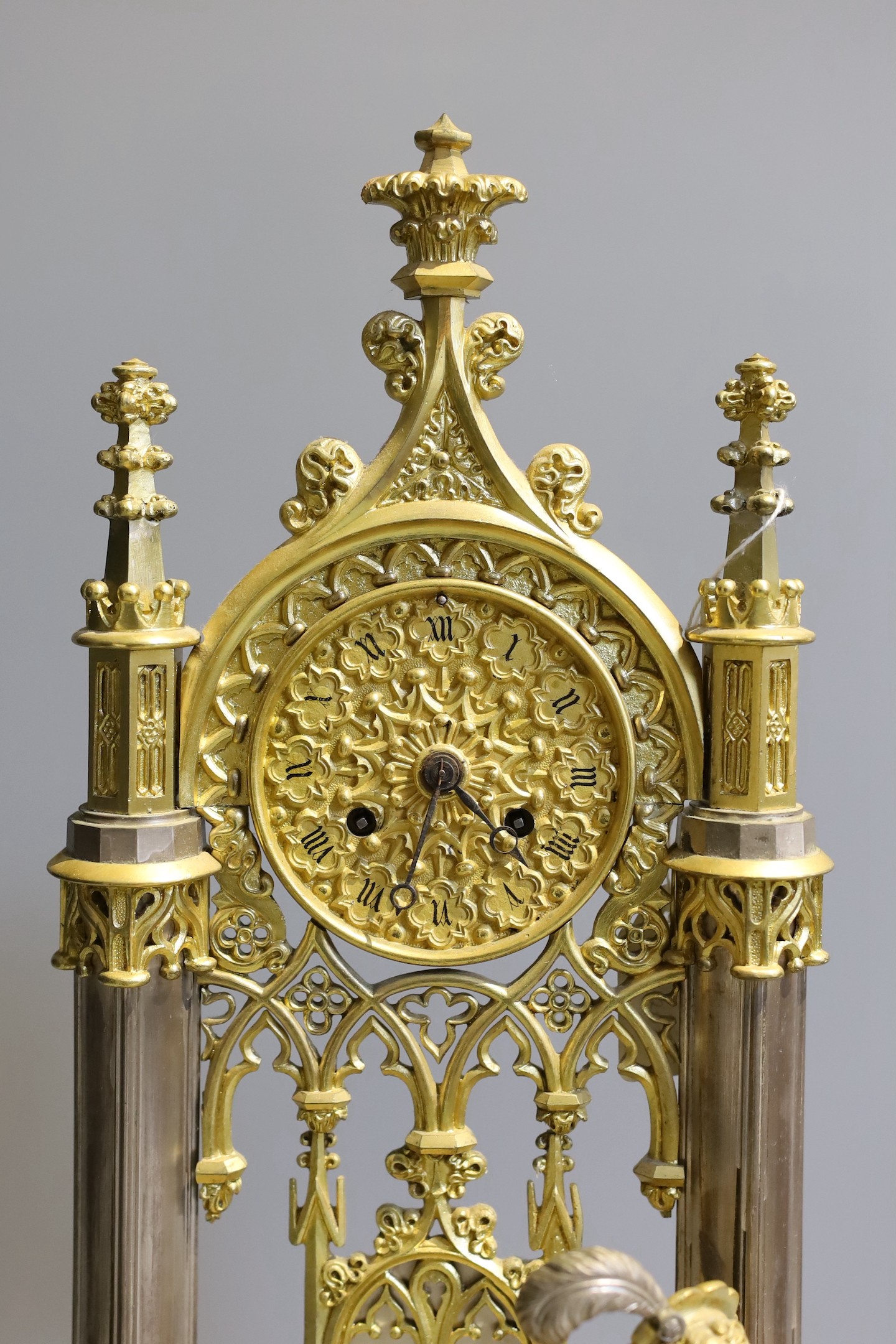 An early 19th century French silvered and gilt metal architectural 8 day mantel clock cast with a seated cavalier with lyre. Height 45 cms.